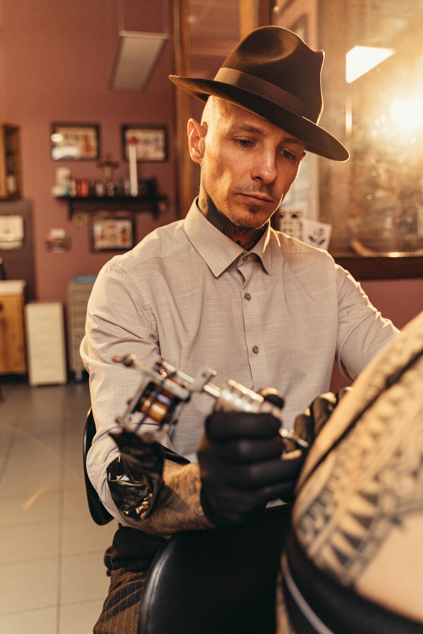 A tattoo artist skillfully working on a client in a studio setting.